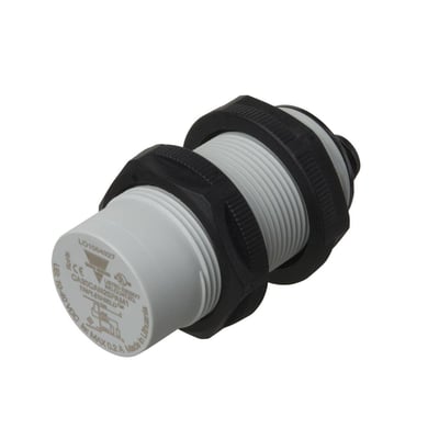 Carlo Gavazzi kapasitiv nærhetsbryter M30, 0-25 mm, med hvitt hus, svart gjenge og låsemuttere, sett skrått forfra.