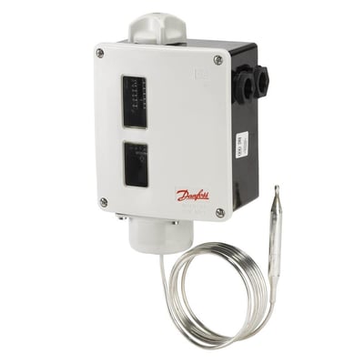 Danfoss RT101-termostat med fjernføler, opprullet kapillarrør og hvitt styrehus, sett skrått forfra.