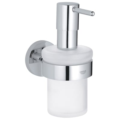 Grohe Essentials sæbedispenser i blank krom og frostet glas monteret på en væg med Grohe logo.