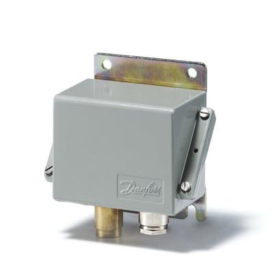 Danfoss CAS pressostat i grå farve, vist fra en vinkel, med synlige tilslutninger og et Danfoss logo på siden.