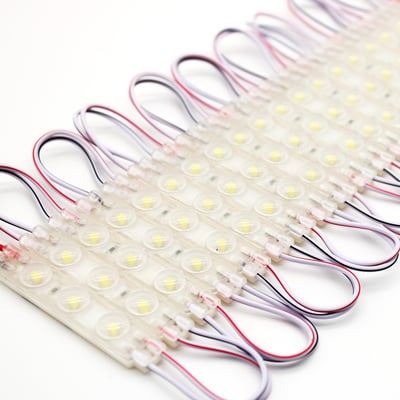 Tæt på visning af LEDlife vandtætte LED moduler med synlige LED'er og ledninger på hvid baggrund.