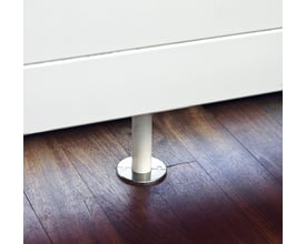 Pipecon-arm Steel Solutions Click-one-two roset i børstet rustfri stål for 22 mm rør, monteret på mørkt trægulv ved en hvid væg.