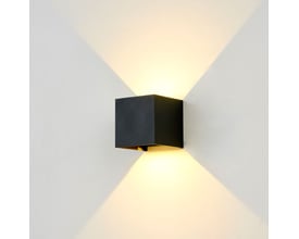 Enkel sort LEDlife Cubic væglampe monteret på en lys væg, med lys der skaber et kryds-mønster.