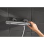 GROHE Grohtherm 1000 Performance dusjarmatur montert på mørke fliser, mens et grep betjenes.