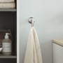 Enkel Duravit Starck T håndklædekrog i krom monteret på en lysgrå væg, med et hvidt håndklæde hængende.