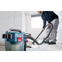 Bosch GAS 18V-10L Professional-støvsuger suger opp vann fra gulvet mens en person fører slangen over det våte området.