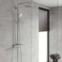 GROHE Euphoria 260 dusjsystem i krom montert i et flislagt dusjområde med glassvegg og vindu.