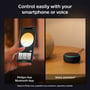 Smartphone der viser Philips Hue app-interface til styring af lys, og en stemmeassistent enhed, der illustrerer smart kontrol.