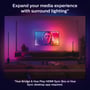 Stue med sofagruppe og tv, hvor to Philips Hue Signe gradient bordlamper i sort oplyser væggen bag tv'et med farverige lysgradienter.