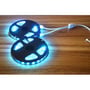 Den hvite RGB+WW-kabelsplitteren fordeler strøm til to blålysende LED-strips på trerekker.