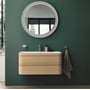 Duravit Starck T håndklædekrog i krom på en mørkegrøn væg, over et lyst træbadeværelsesmøbel med vask og spejl.