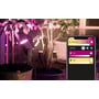 Philips Hue Lily spot lyser med lilla farve ved en plante, ved siden af en smartphone der viser Hue app styring.